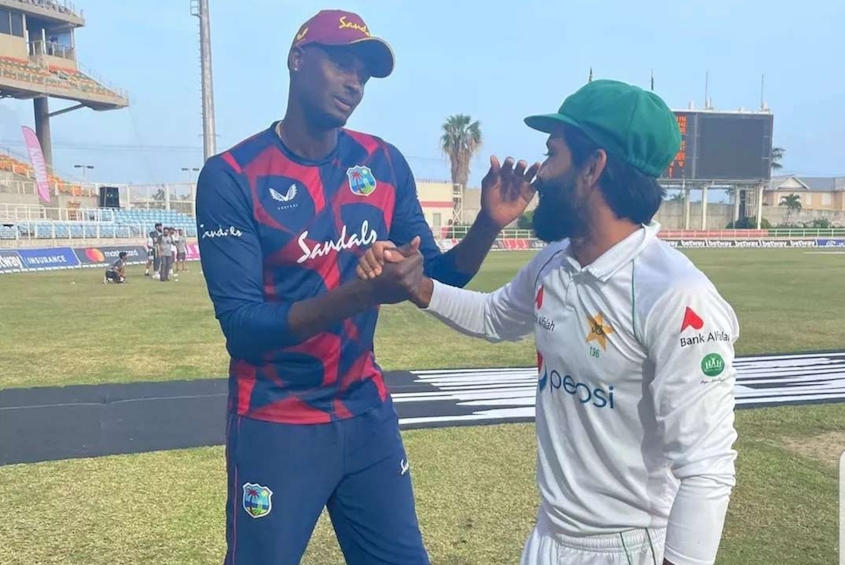 Jason Holder with Fawad Alam